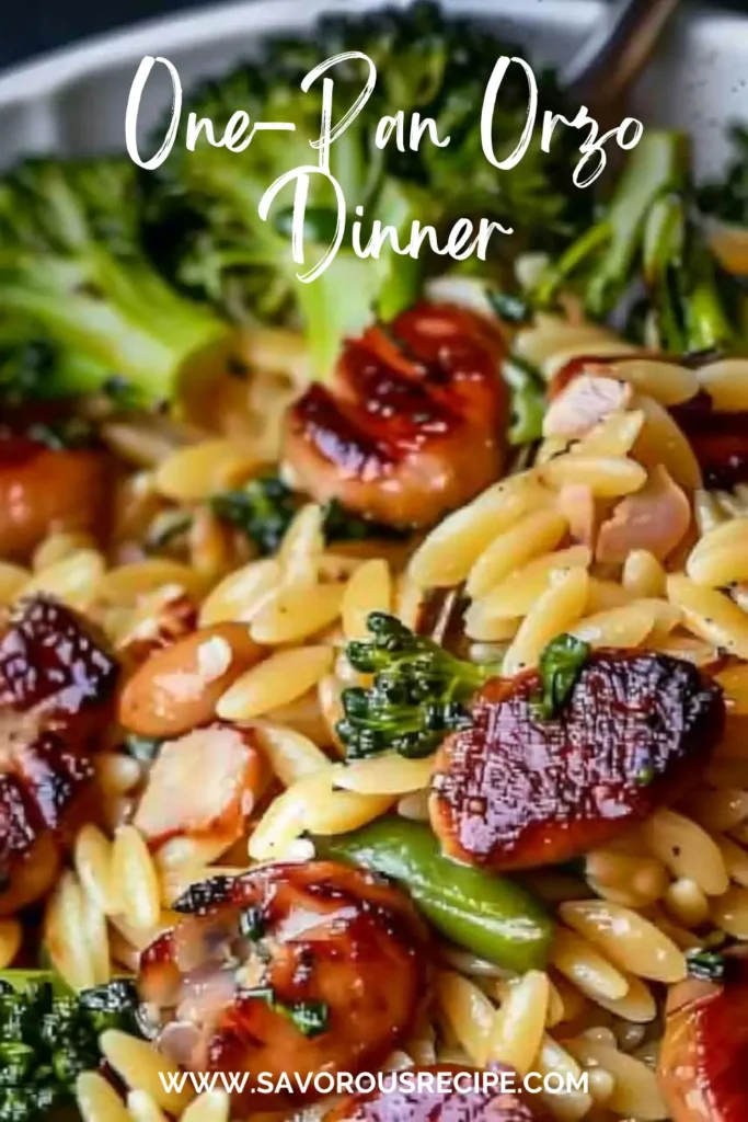 Close-up of creamy orzo pasta with browned sausage slices, tender broccoli florets, and melted Parmesan cheese in a skillet.
