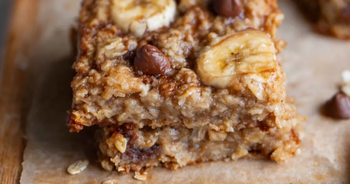 close-up of chewy banana oat squares topped with sliced bananas and chocolate chips