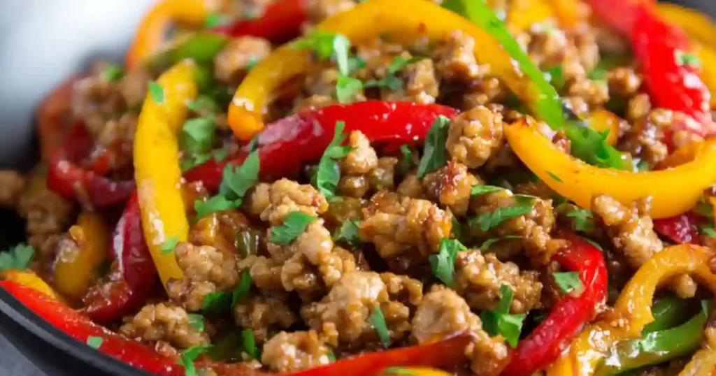Ground turkey stir fry with red, yellow, and green bell peppers topped with fresh parsley
