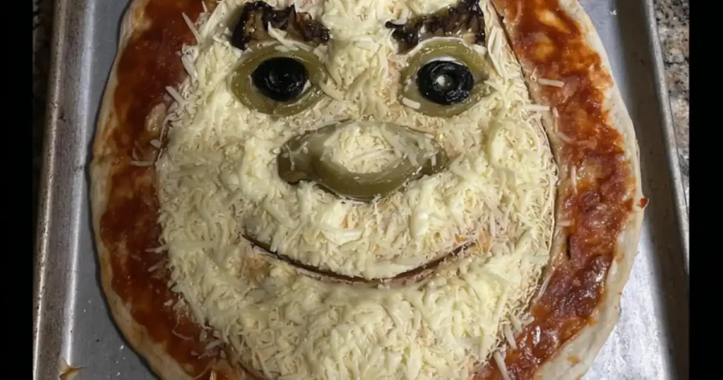 Cheese pizza decorated to resemble Shrek’s face with olives, jalapeños, and melted mozzarella