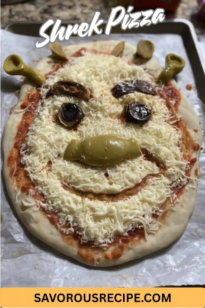 Homemade pizza decorated with mozzarella, olives, and peppers to resemble Shrek’s face, styled with text and branding