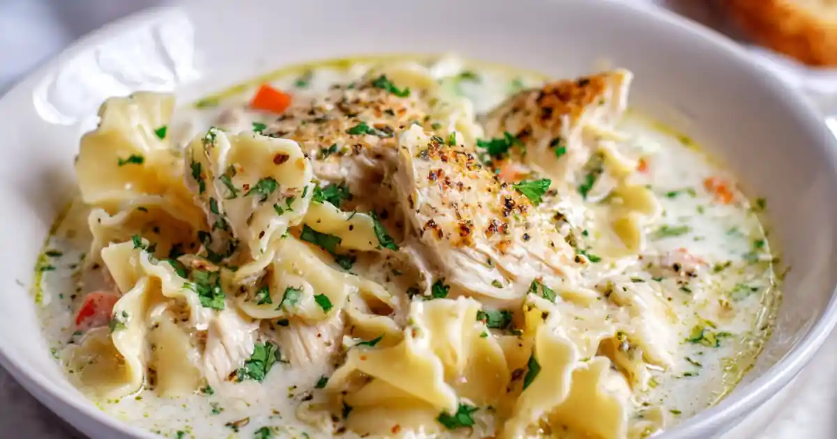 creamy white lasagna soup with grilled chicken and ruffled pasta in a white bowl