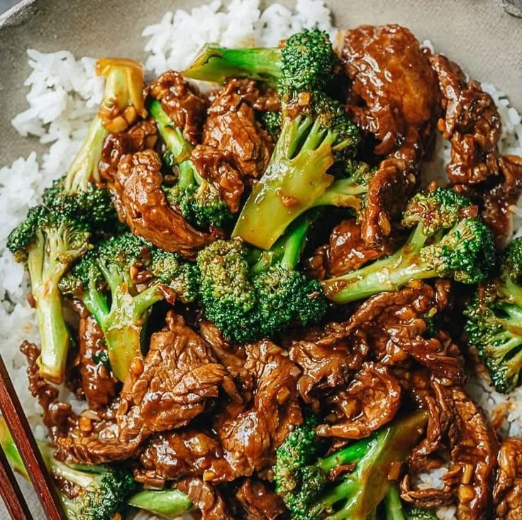 Plate of Chinese Beef and Broccoli with sauce and fresh vegetables