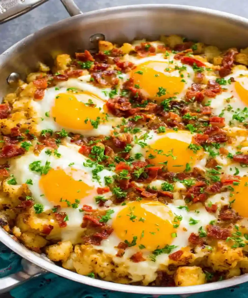 crispy bacon and sunny-side-up eggs in breakfast skillet with herbs
