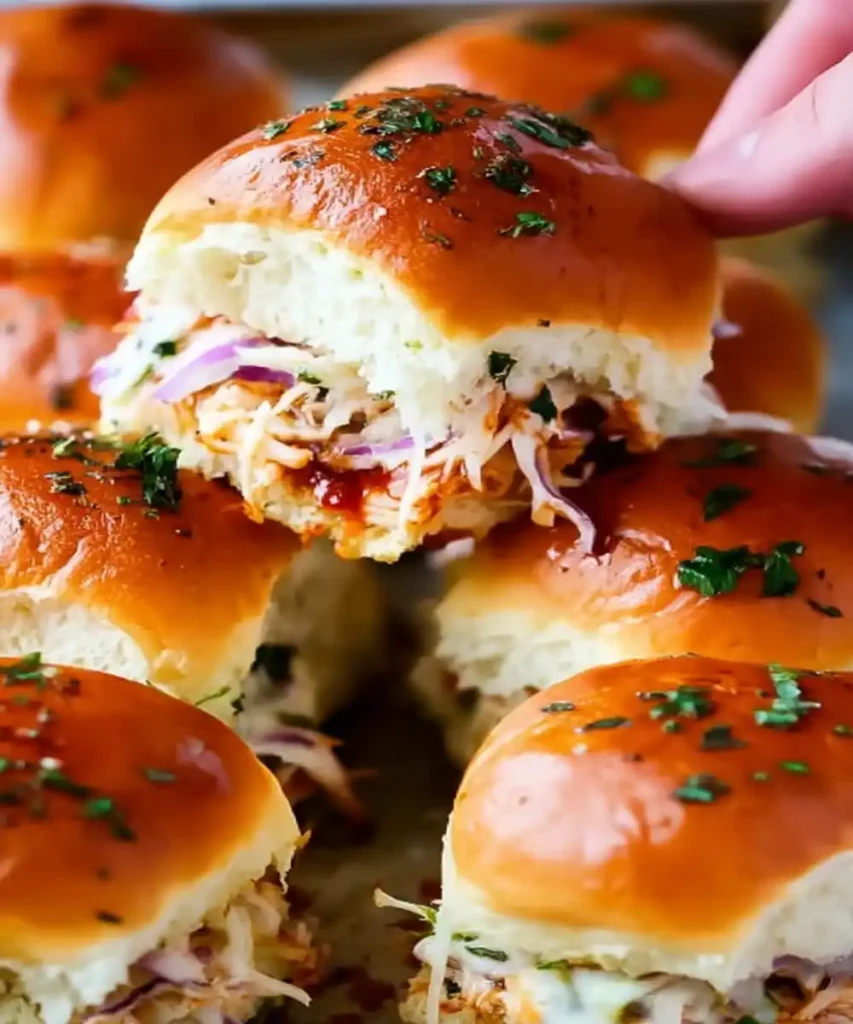 BBQ chicken sliders with coleslaw on toasted brioche buns, garnished with parsley