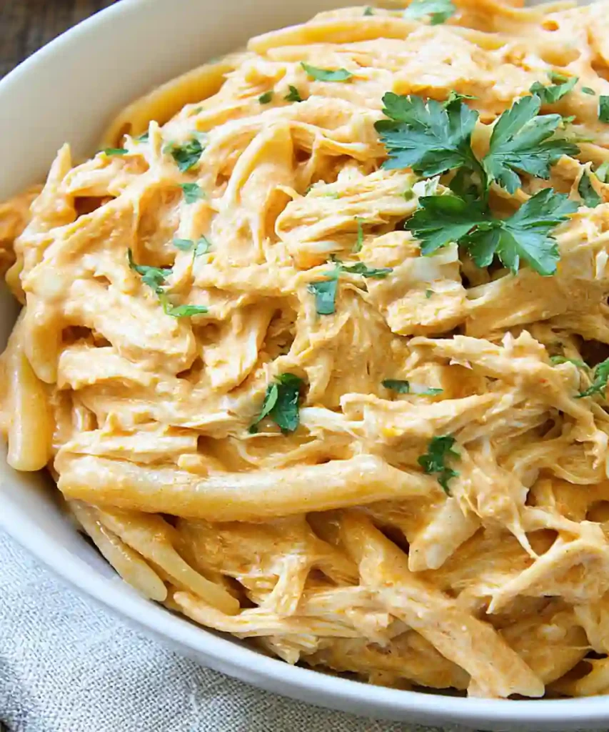 creamy buffalo chicken pasta with shredded chicken, penne, and parsley garnish