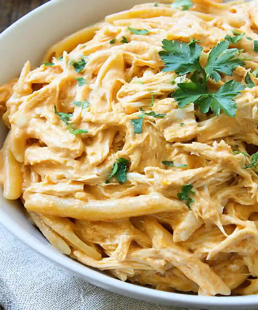 creamy buffalo chicken pasta with shredded chicken, penne, and parsley garnish