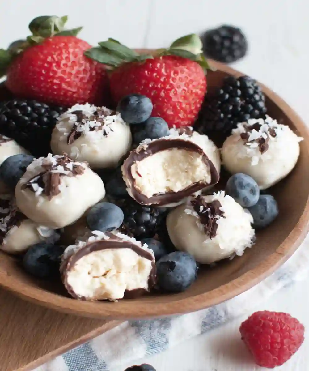frozen yogurt berry bites with shredded coconut and dark chocolate served with mixed berries