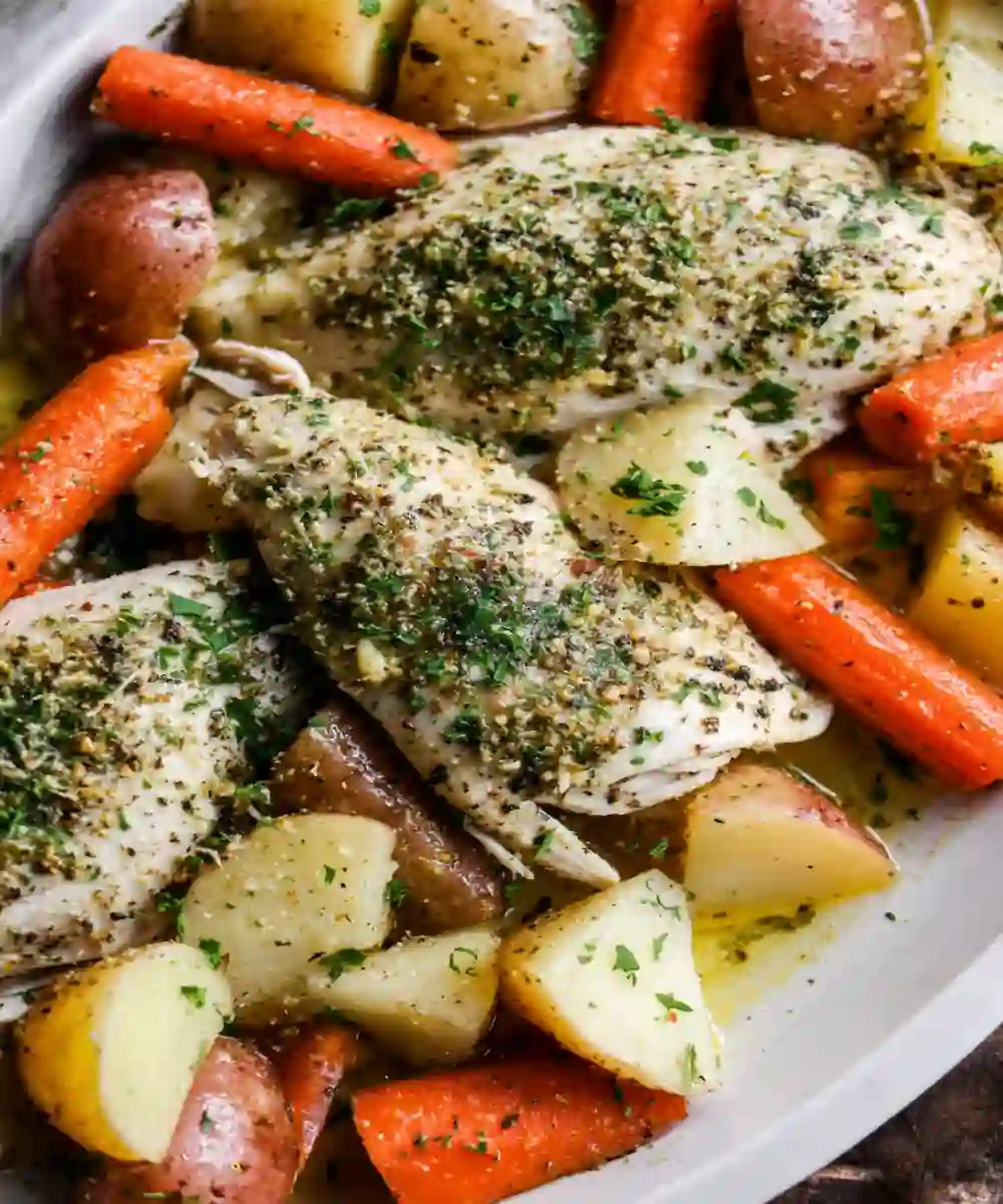 slow-cooked herb chicken with baby potatoes and carrots on a serving dish