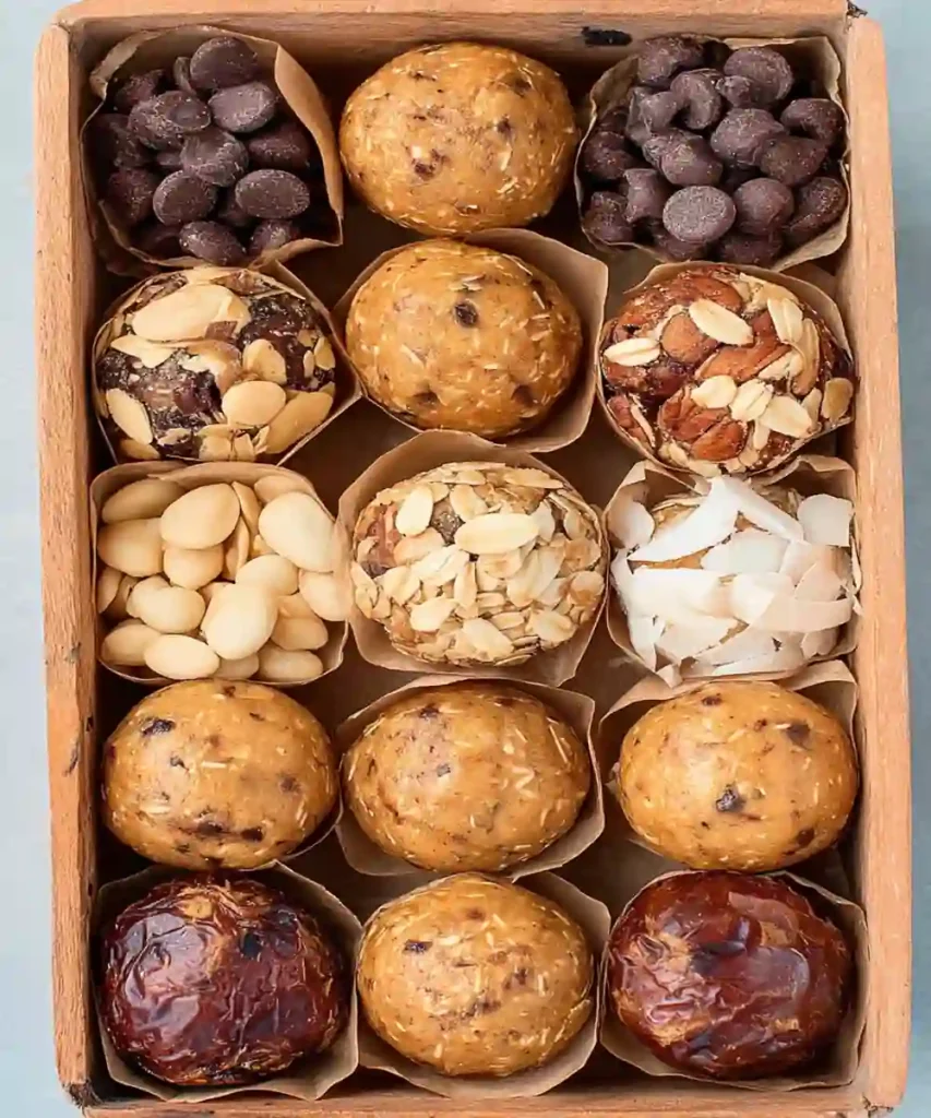 assorted protein energy balls with oats, chocolate, coconut, and nuts in a wooden box
