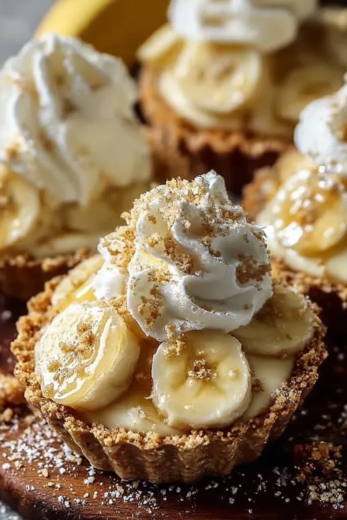 No-bake mini banana cream pies topped with whipped cream and banana slices