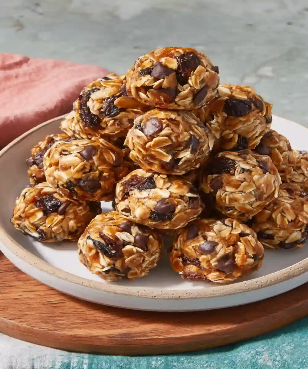 no-bake protein balls with oats, chocolate chips, and dried fruit stacked on a plate