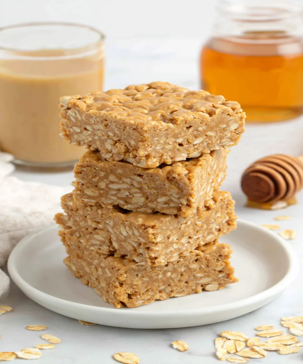 Healthy no-bake peanut butter honey oat bars stacked on a white plate