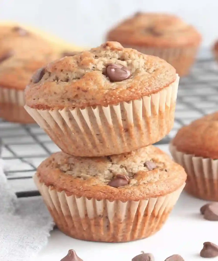 stacked banana protein muffins with chocolate chips on cooling rack