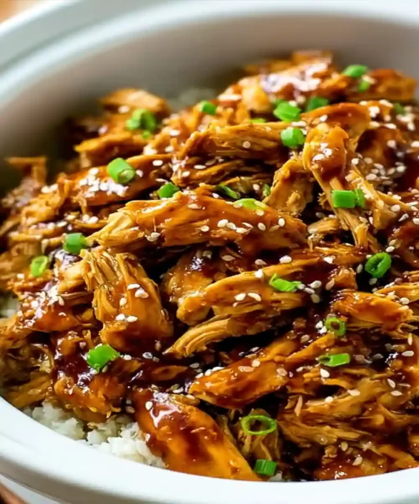 shredded sweet teriyaki chicken with sesame seeds and green onions over white rice
