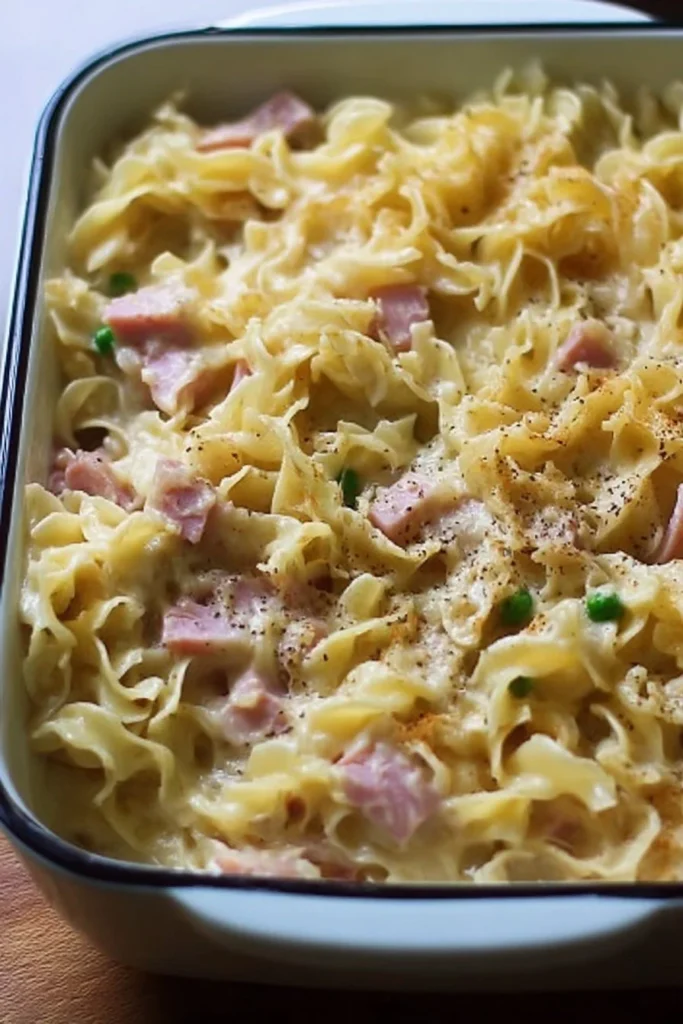 Delicious ham noodle casserole topped with cheese and herbs