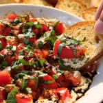 Delicious Bruschetta Dip served in a bowl with fresh tomatoes and basil.