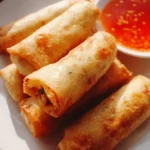 Plate of crispy Chinese vegetable spring rolls served with dipping sauce