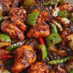 Plate of easy black pepper chicken garnished with fresh herbs.