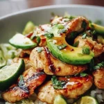 Honey Lime Chicken with Avocado served on a plate garnished with fresh herbs