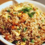 Delicious plate of restaurant style fried rice garnished with vegetables and herbs