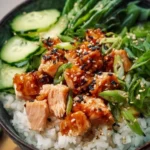 Spicy canned salmon rice bowl topped with fresh vegetables and sesame seeds