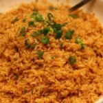 Bowl of Texas Roadhouse seasoned rice garnished with herbs