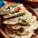 Plate of homemade Tlacoyos topped with cheese and salsa