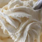 Vanilla American Buttercream Frosting in a bowl with a spatula