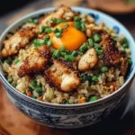 Crispy Garlic Chicken Fried Rice Bowl garnished with fresh herbs and vegetables