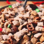 Bowl of Reindeer Chow festive holiday snack mix with colorful ingredients.