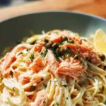 Plate of savory smoked salmon linguine garnished with herbs and lemon