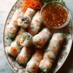 Delicious shrimp spring rolls garnished with fresh herbs and served with dipping sauce.