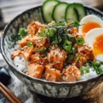 Spicy canned salmon rice bowl topped with fresh vegetables and sauces.