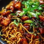 Delicious sticky garlic chicken noodles served in a bowl with vegetables