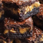 Delicious and decadent outrageous Snickers brownies topped with caramel and peanuts