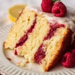 A slice of vibrant raspberry lemon cake showcasing fresh raspberries and lemon zest.