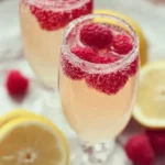 A refreshing glass of Raspberry Limoncello Prosecco garnished with raspberries