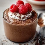 A bowl of blended chocolate chia pudding topped with fresh berries and mint