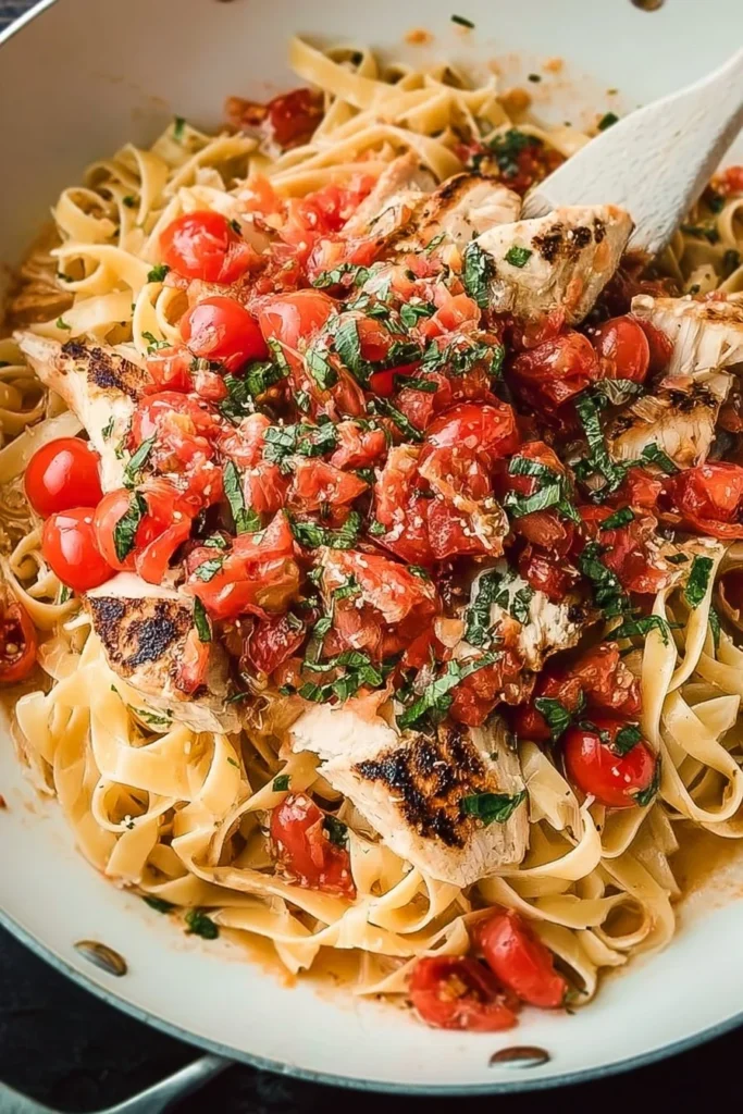 Delicious Bruschetta Chicken Pasta topped with fresh herbs and tomatoes