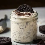 Bowl of cookies and cream overnight oats topped with chocolate and cookie crumbles.