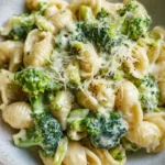 Creamy broccoli pasta dish with fresh ingredients served in a bowl.
