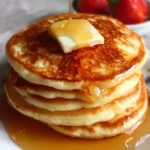 Stack of easy fluffy pancakes served with syrup and berries