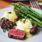 Eggs Benedict with grilled steak and asparagus served on a plate