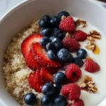 Delicious yogurt quinoa bowl topped with fresh fruits and nuts