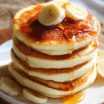 Stack of delicious fluffy pancakes served with maple syrup and berries
