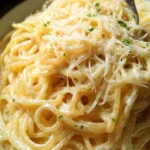 Delicious bowl of Garlic Parmesan Pasta topped with herbs and cheese