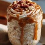 High protein cinnamon roll overnight oats in a bowl, topped with cinnamon and nuts