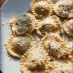 Homemade ravioli filled with cheese and herbs, served with tomato sauce.