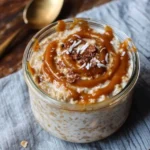 Bowl of no-cook caramel oatmeal topped with caramel sauce and nuts.